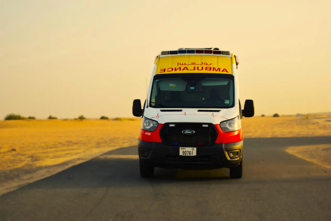 An ART ambulance photographed head-on at sunset on a desert road outside Dubai
